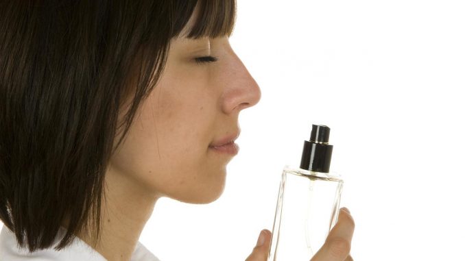 Женщина нюхает запах духов
